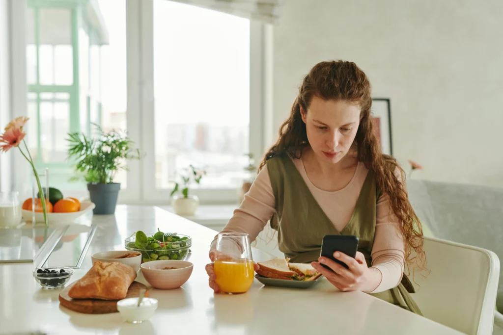 Mujer embarazada comiendo alimentos saludables en casa como parte de su preparación para la maternidad